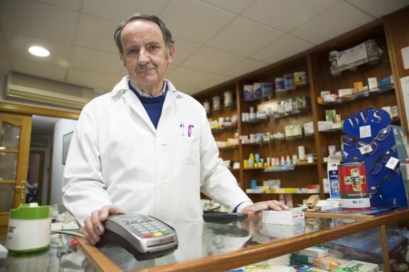 Manuel Bernárdez muestra el TPV de su farmacia en Nívar, donde no hay ni oficinas bancarias ni tampoco cajeros.