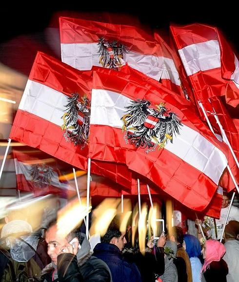 Un grupo de personas muestra banderas austriacas en Viena en una marcha de refugiados en la que daban las gracias a la acogida brindada por el país. 
