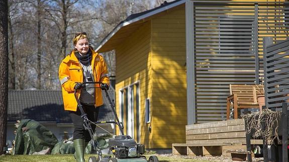 Una cartera pasa el cortacésped en el jardín de un cliente del servicio postal finlandés. 