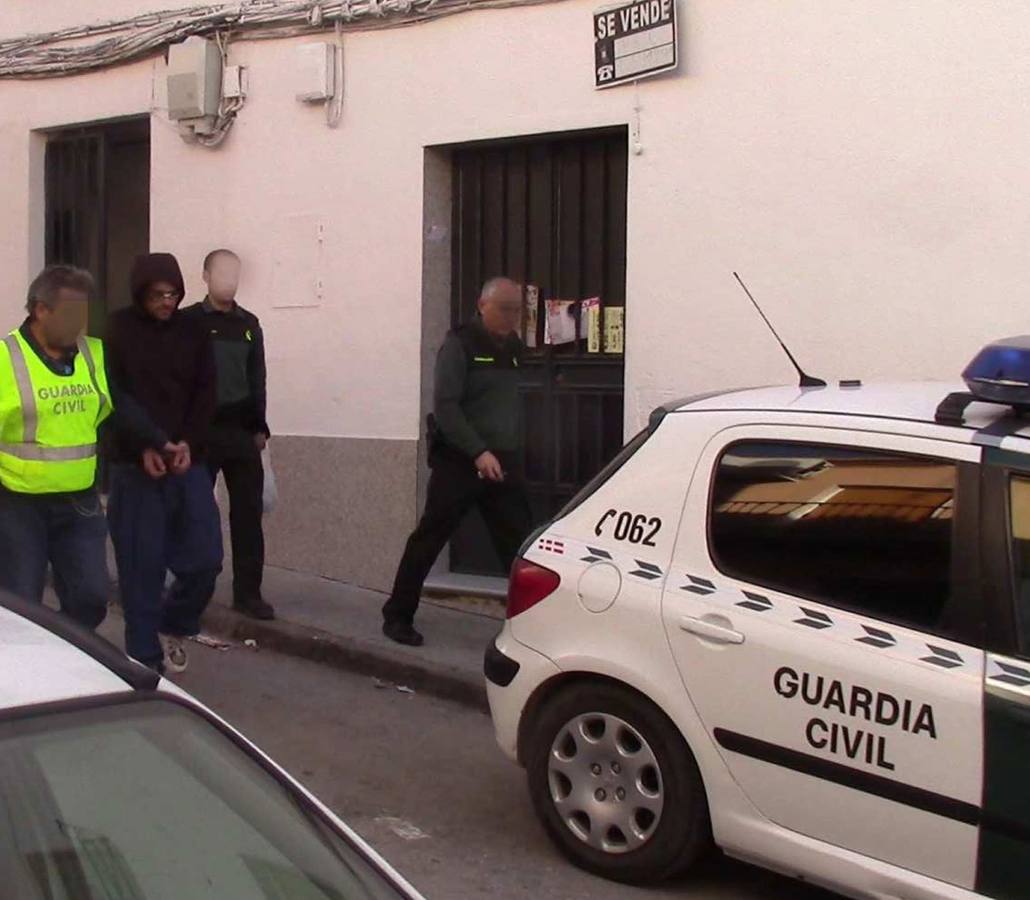 Agentes de la guardia civil trasladan al calabozo a uno de los detenidos por el asalto de una vivienda en Torredelcampo.