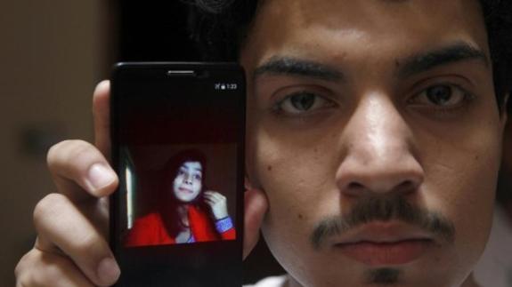 El marido muestra una foto ed su mujer quemada. 