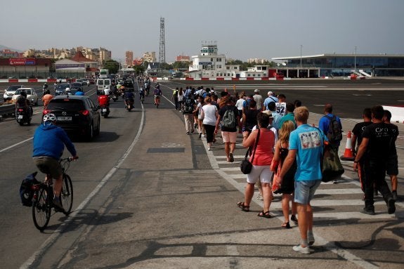 Peatones y conductores cruzan la pista del aeropuerto de Gibraltar, junto a la frontera con España.