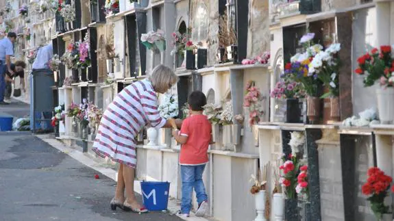 Una señora deja flores en uno de los nichos del cementerio de San José y Santa Adela de Almería.