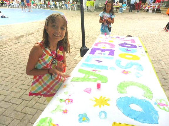 Celia, valdepeñera de 10 años de edad, junto a un cartel con el mensaje 'todos con Celia', que pretende visibilizar su enfermedad.