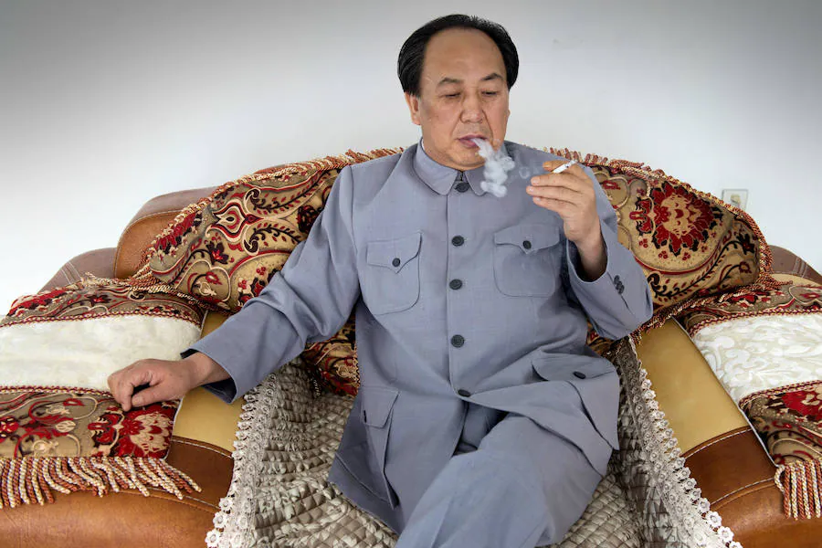 Zhenlong, en su casa, se fuma un cigarrillo como lo hacía Mao. El empresario solo necesita un poco de arcilla para imitar su característica verruga. 