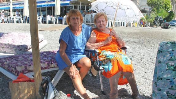 Amadora (90 años) junto a su sombrilla y su hija en las hamacas de Pepe, Dígame, su chiringuito de toda la vida. 