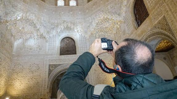 Un turista hace fotos en el interior de los Palacios Nazaríes en la Alhambra. 
