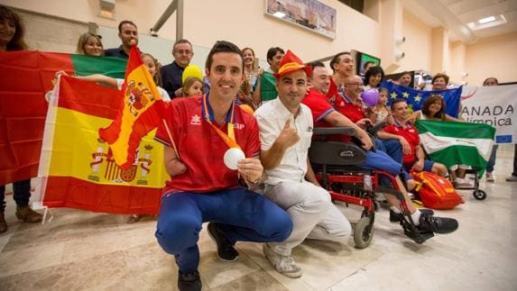 Familiares, amigos y miembros de distintos colectivos, junto a los deportistas en el aeropuerto de Granada.  