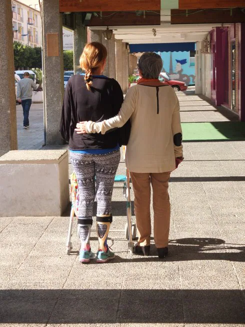 Lidia camina por la calle Blas Infante acompañada de su madre, Carmen.