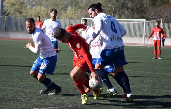 Un jugador del Almería B trata de marcharse de Choco y Rafilla.