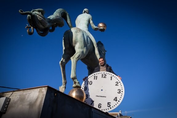 Manuel Pinel posa, junto al caballo que remata la cubierta del Ayuntamiento, con la esfera del antiguo reloj que marcaba las horas en la plaza del Carmen.