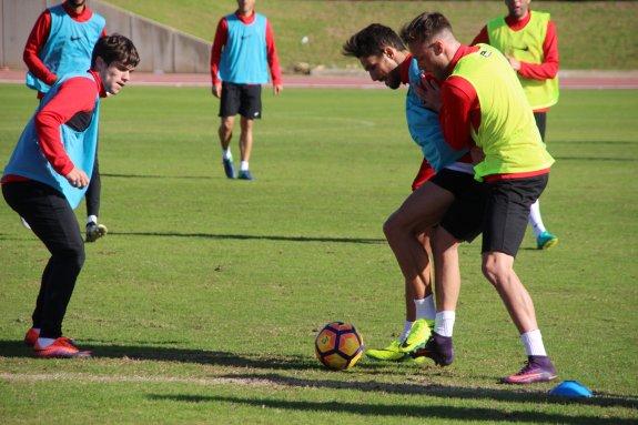 Fidel protege el balón, en presencia de José Ángel Pozo y acosado por José Ángel Jurado. 