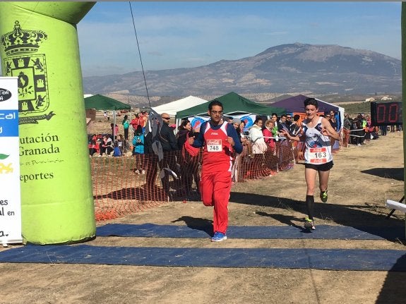 Antonio Fernández (i), que compite en la categoría adaptada, entra en la meta acompañado por Iván Moreno, bronce juvenil.