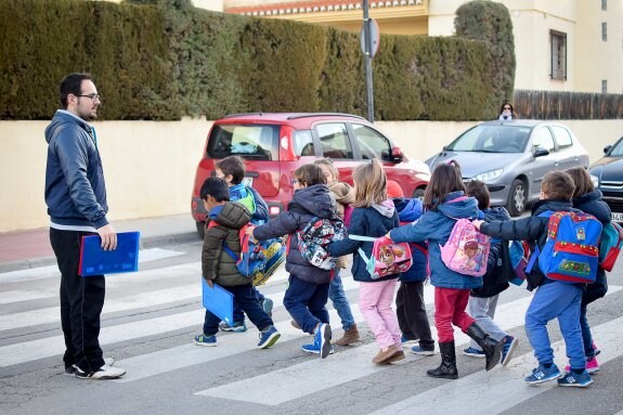 Un grupo de niños cruza un paso de cebra camino de su colegio en Ambroz. 