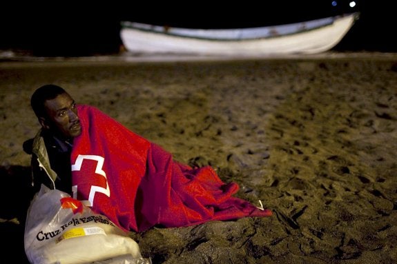 Un inmigrante subsahariano recibe ayuda de Cruz Roja tras llegar a una playa andaluza.