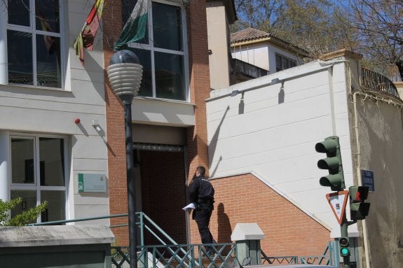 Un agente de Policía entra el edificio donde está el juzgado instructor.