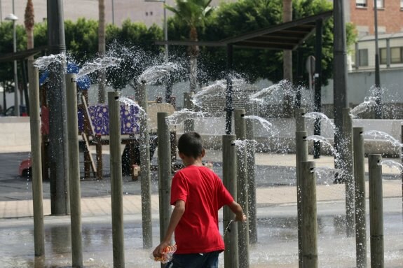 Un niño juega con el agua en la fuente de la plaza de la Concordia, en la capital