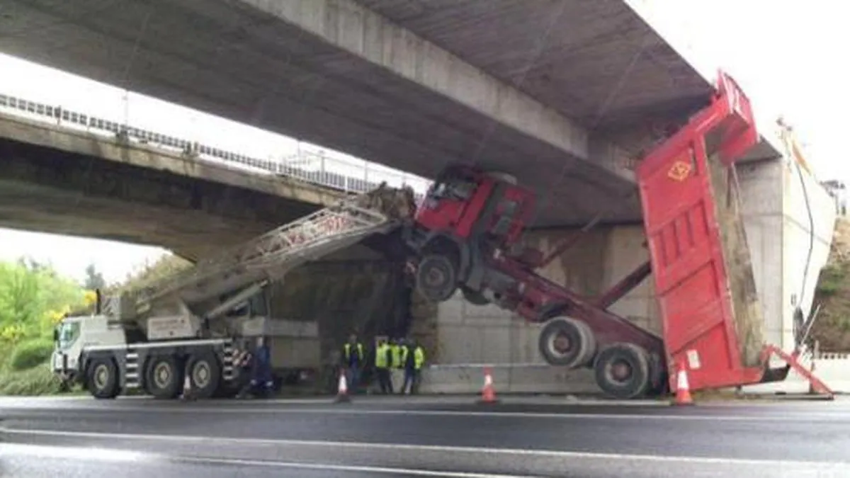 Un camión queda atascado en un puente al viajar con el volquete subido