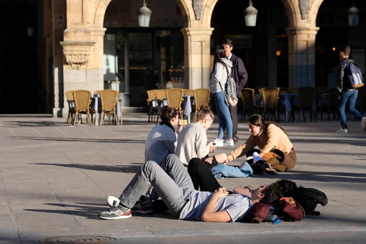 Varios jóvenes disfrutando del buen tiempo en la Plaza Mayor.