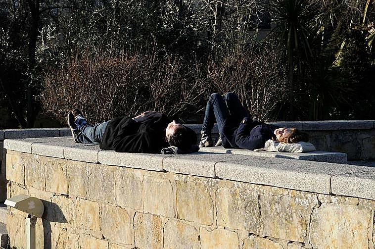 Dos jóvenes duermen la siesta en un parque de Salamanca