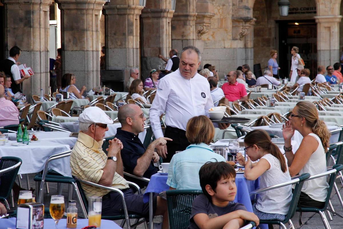 Un camarero atiende a los clientes en una terraza de la Plaza Mayor.