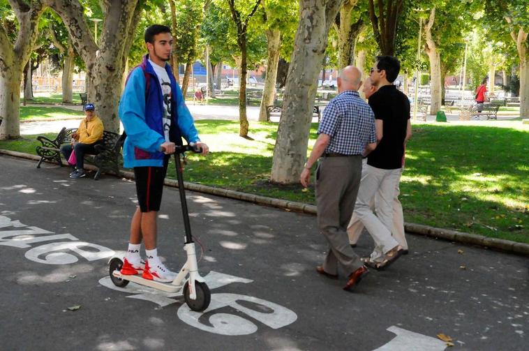 Cea circula por la calzada del parque de la Alamedilla con su patinete eléctrico.