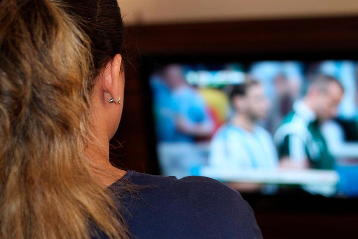 Una persona viendo el fútbol en la televisión.