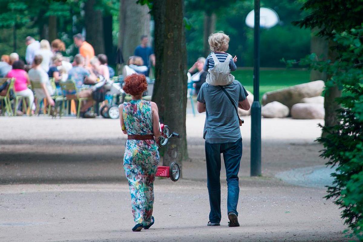 Una familia paseando por un parque.