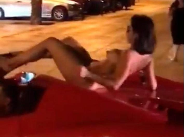 La mujer desnuda sobre el Ferrari.