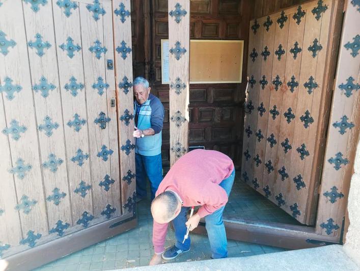 Dos vecinos intentaban reparar la puerta de la iglesia