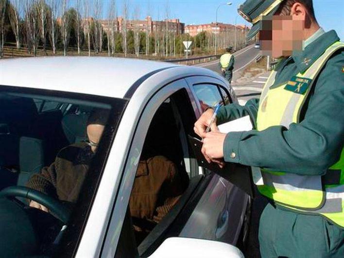 Un agente de la Guardia Civil, tramita una multa.