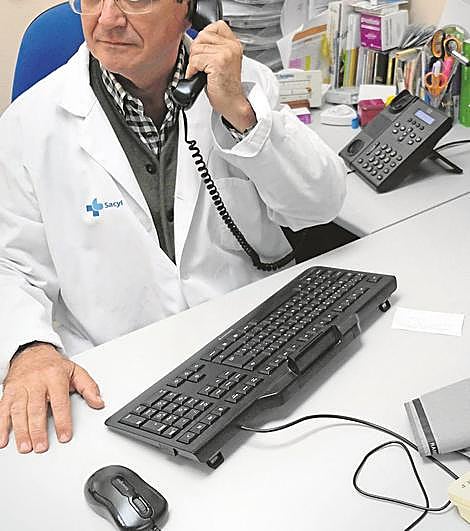 Un médico de familia atiende una llamada telefónica de un paciente.