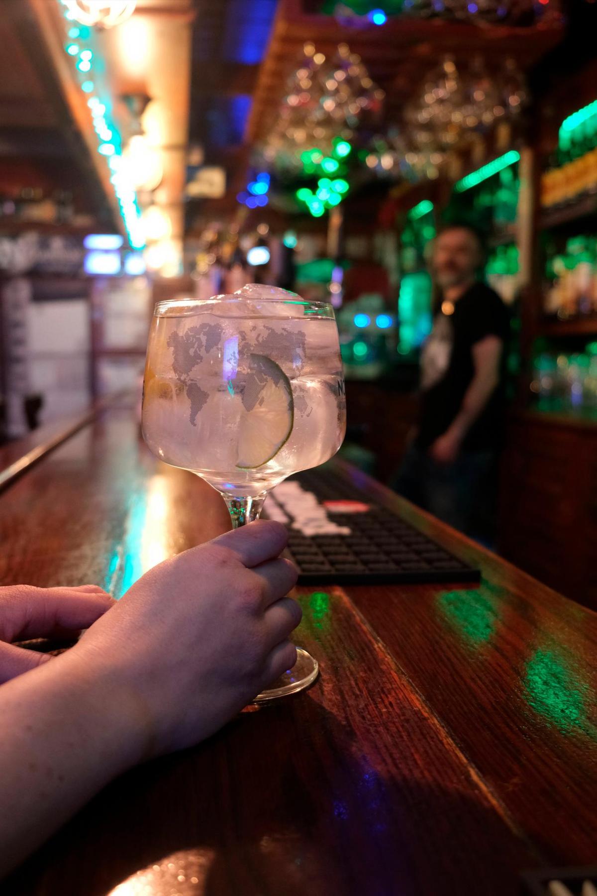 Una mujer, ajena a esta información, disfruta de una copa en un bar.