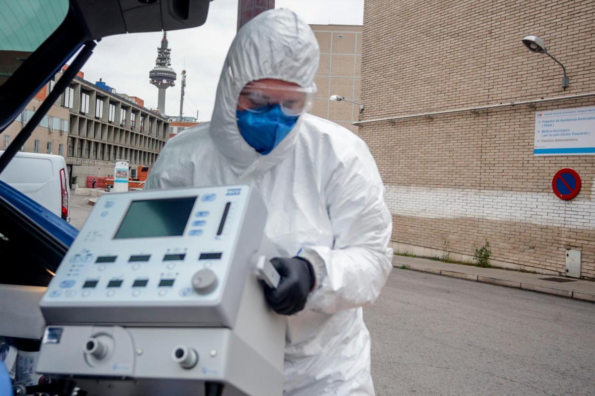 Un sanitario saca un respirador de un maletero.