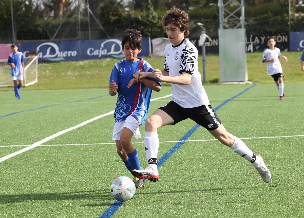 Un cadete del Trinitarios trata de frenar a otro del Salamanca UDS, en un choque de Segunda división disputado este curso en El Tori.