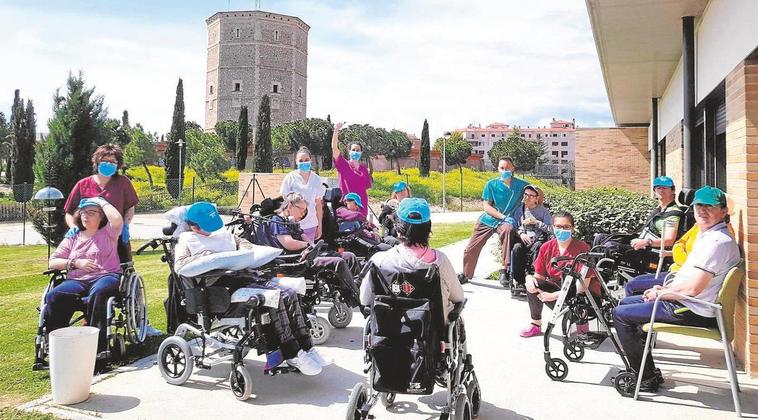 Los usuarios de la residencia de Asdem, con los profesionales, en el jardín.