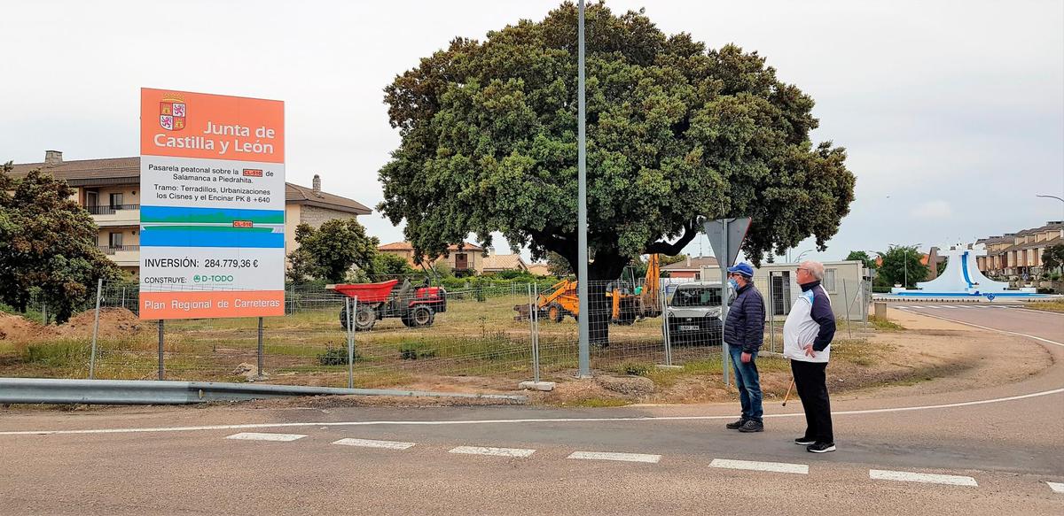 Dos vecinos observan el  inicio de las obras de la esperada pasarela.