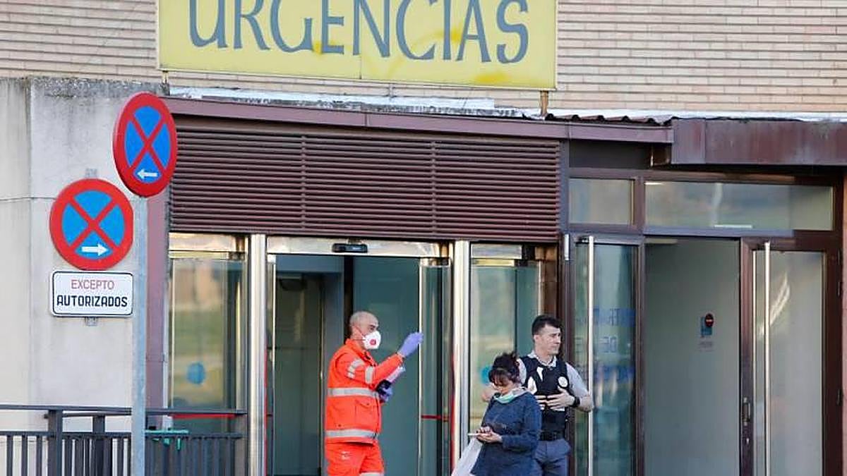 Un sanitario y una mujer con mascarillas a la puerta de las Urgencias del Hospital Clínico de Salamanca.