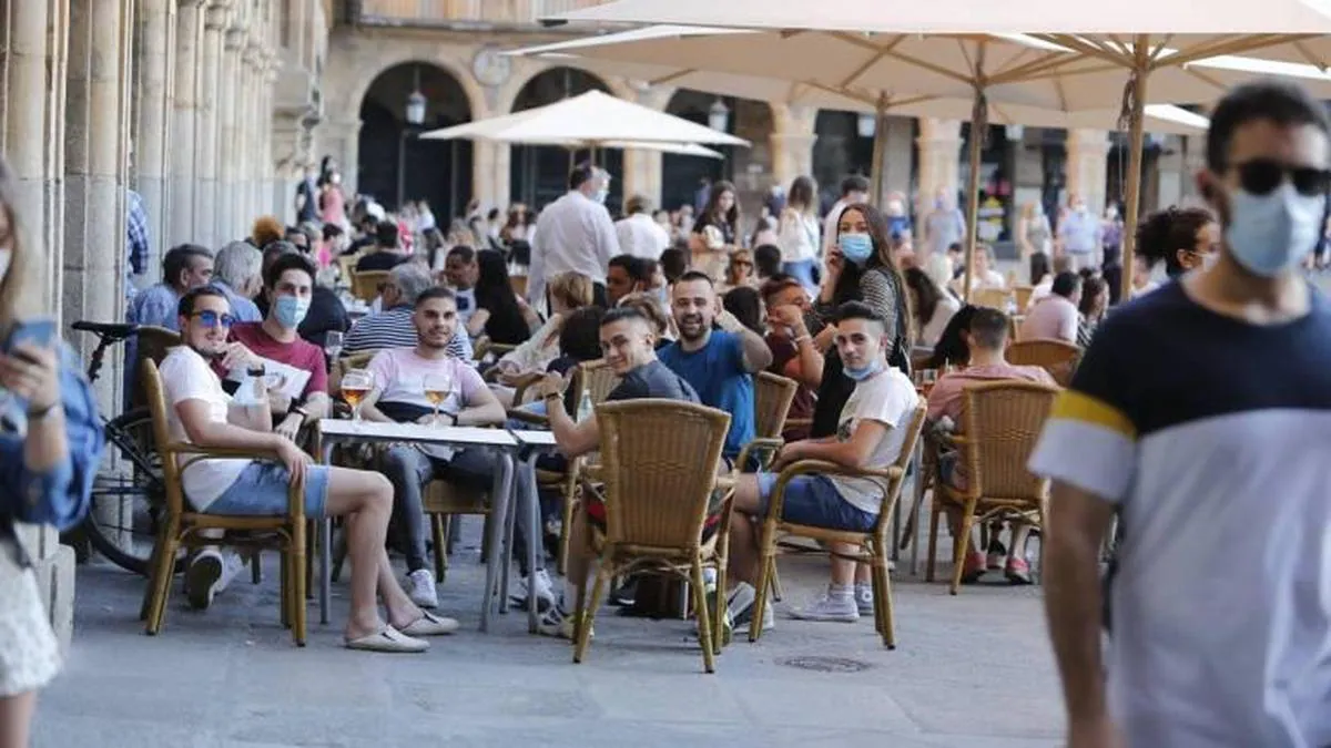 Un grupo de amigos tomando una caña en una terraza de la Plaza Mayor.