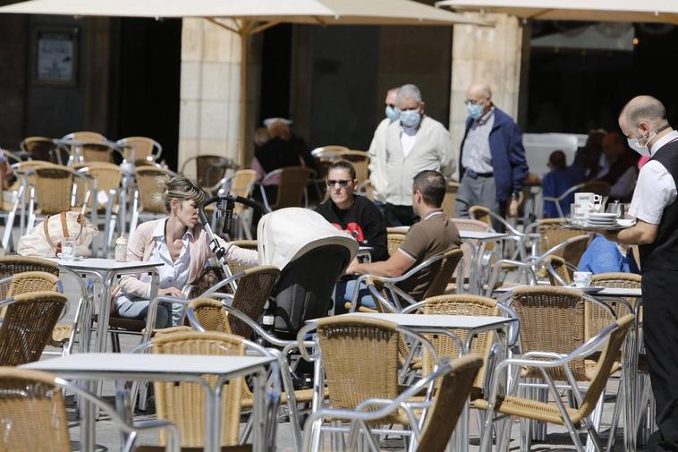 Salmantinos en una terraza y paseando por la Plaza.