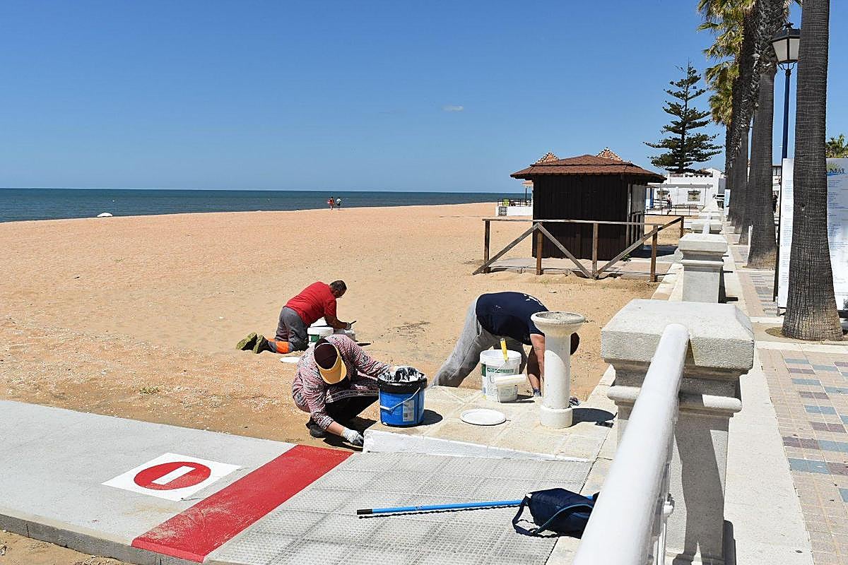 Operarios preparando una playa en Lepe a principios de mes.