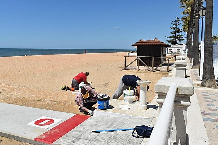 Operarios preparando una playa en Lepe a principios de mes.