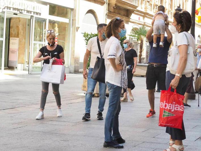 Salmantinos con bolsas de diferentes establecimientos en la calle Toro.