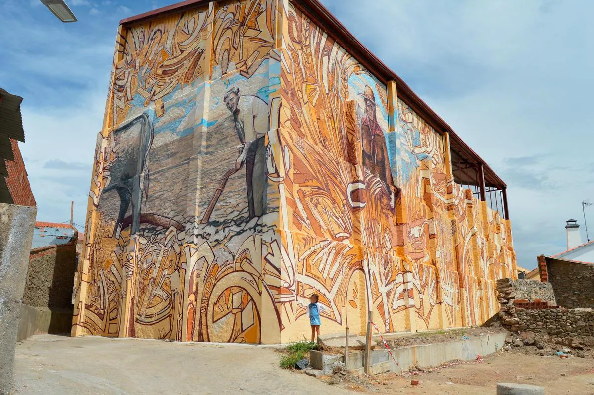 “La cosecha” es la primera obra de arte rural en un pueblo de Salamanca del artista Daniel Martín que ha dejado su inconfundible huella a lo largo de este enorme mural de Palacios del Arzobispo.