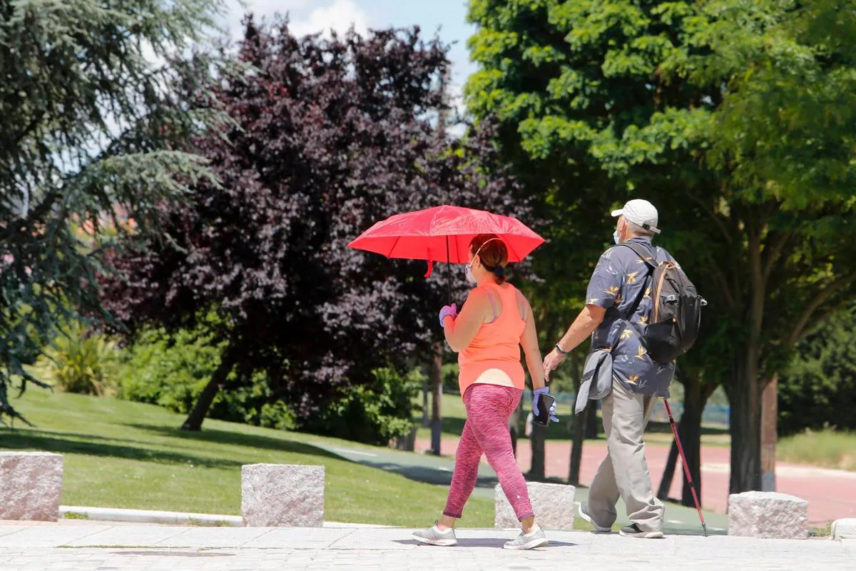 Dos personas caminan por la capital protegiéndose con un paraguas