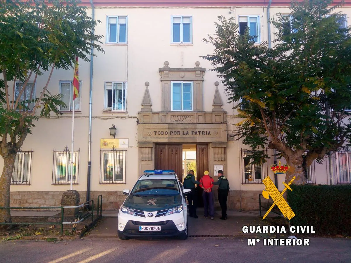 Uno de los detenidos custodiado por los agentes.