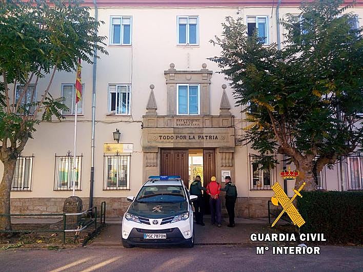 Uno de los detenidos custodiado por los agentes.