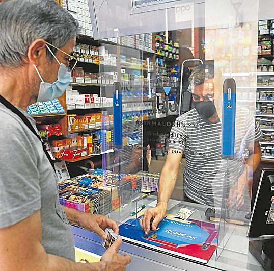 Un salmantino comprando una cajetilla de cigarrillos en un estanco.