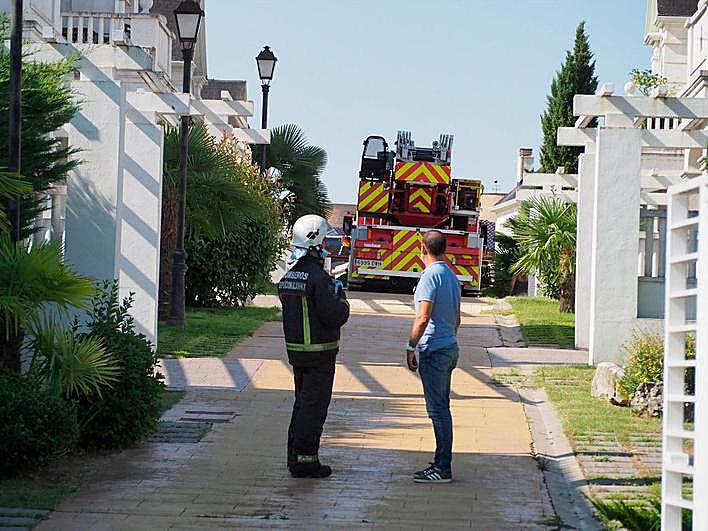 El alcalde de Carbajosa, Pedro Samuel Martín, dialoga con un bombero junto al chalé donde se registró el incendio.