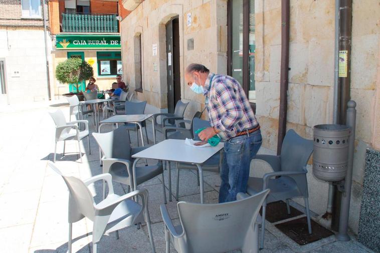 Un hostelero de Cantalpino desinfectando ayer las mesas y sillas de la terraza tras retomar la actividad.